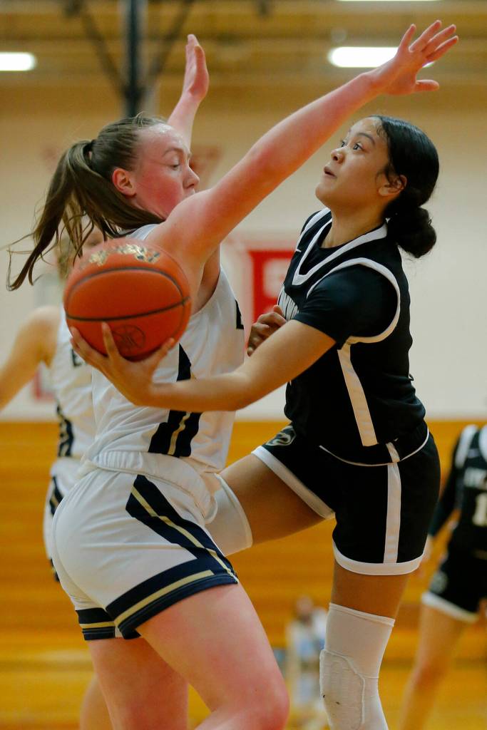 Lynnwoods Aniya Hooker tries for the scoop shot against Arlington on Tuesday, Feb. 14, 2023, at Marysville Pilchuck High School in Marysville, Washington. (Ryan Berry / The Herald)