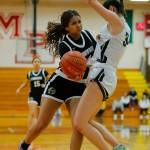 Arlingtons Jenna Villa draws a charging foul on Lynnwoods Dina Yonas on Tuesday, Feb. 14, 2023, at Marysville Pilchuck High School in Marysville, Washington. (Ryan Berry / The Herald)