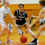 Lynnwoods Aniya Hooker gets pestered by the defense before passing off the ball against Arlington on Tuesday, Feb. 14, 2023, at Marysville Pilchuck High School in Marysville, Washington. (Ryan Berry / The Herald)