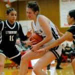 Arlington’s Jenna Villa muscles the ball away from the offense for a rebound against Lynnwood on Tuesday, Feb. 14, 2023, at Marysville Pilchuck High School in Marysville, Washington. (Ryan Berry / The Herald)