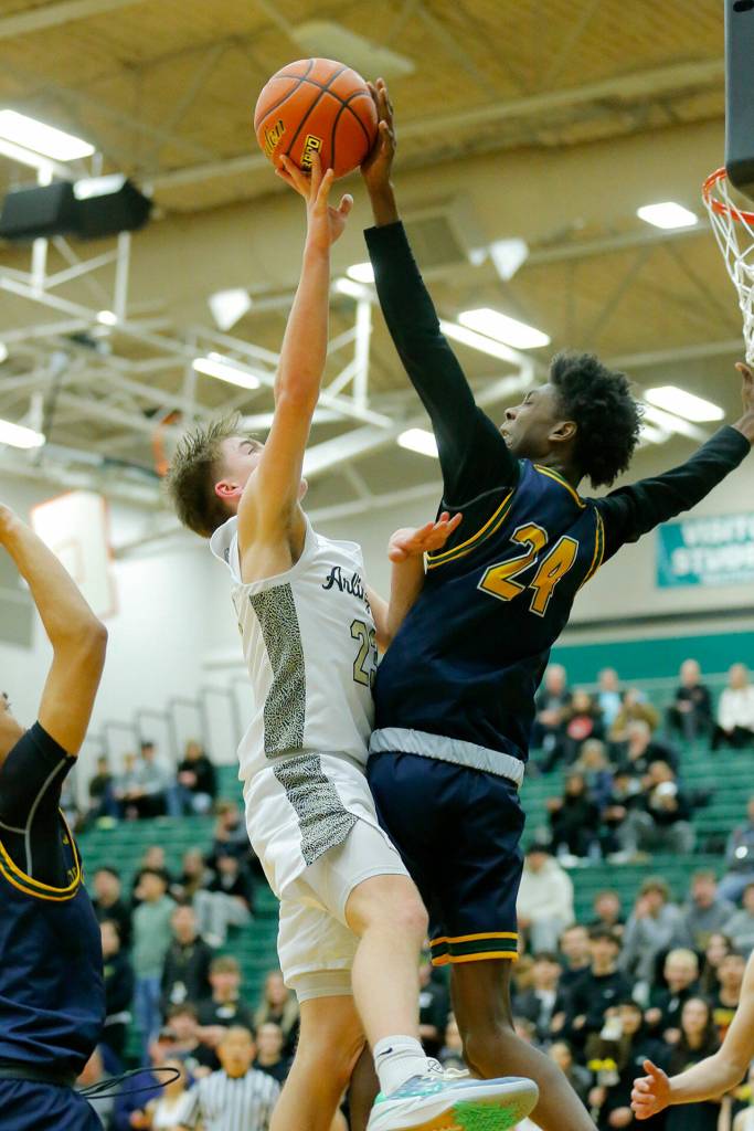 Shorecrests Adarrius Hilliard records a big block on Leyton Martin against Arlington on Wednesday, Feb. 15, 2023, at Jackson High School in Mill Creek, Washington. (Ryan Berry / The Herald)