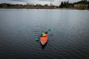 Dave Ellingson, 25, paddles around Lake Ballinger for practice on Saturday, Feb. 18, 2023 in Mountlake Terrace, Washington. (Olivia Vanni / The Herald)