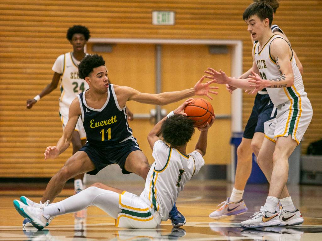 Shorecrests Keaine Silimon tries to pass off the ball to his teammate while Everetts Isaiah Parker tries to steal the ball during the game on Friday, Feb. 17, 2023 in Everett, Washington. (Olivia Vanni / The Herald)