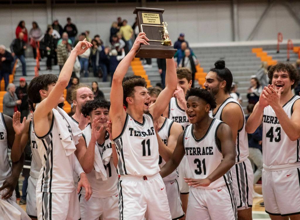 Mountlake Terraces Chris Meegan lifts the 3A District 1 championship trophy in the air after being Arlington on Saturday, Feb. 18, 2023 in Everett, Washington. (Olivia Vanni / The Herald)