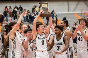 Mountlake Terrace’s Chris Meegan lifts the 3A District 1 championship trophy in the air after being Arlington on Saturday, Feb. 18, 2023 in Everett, Washington. (Olivia Vanni / The Herald)