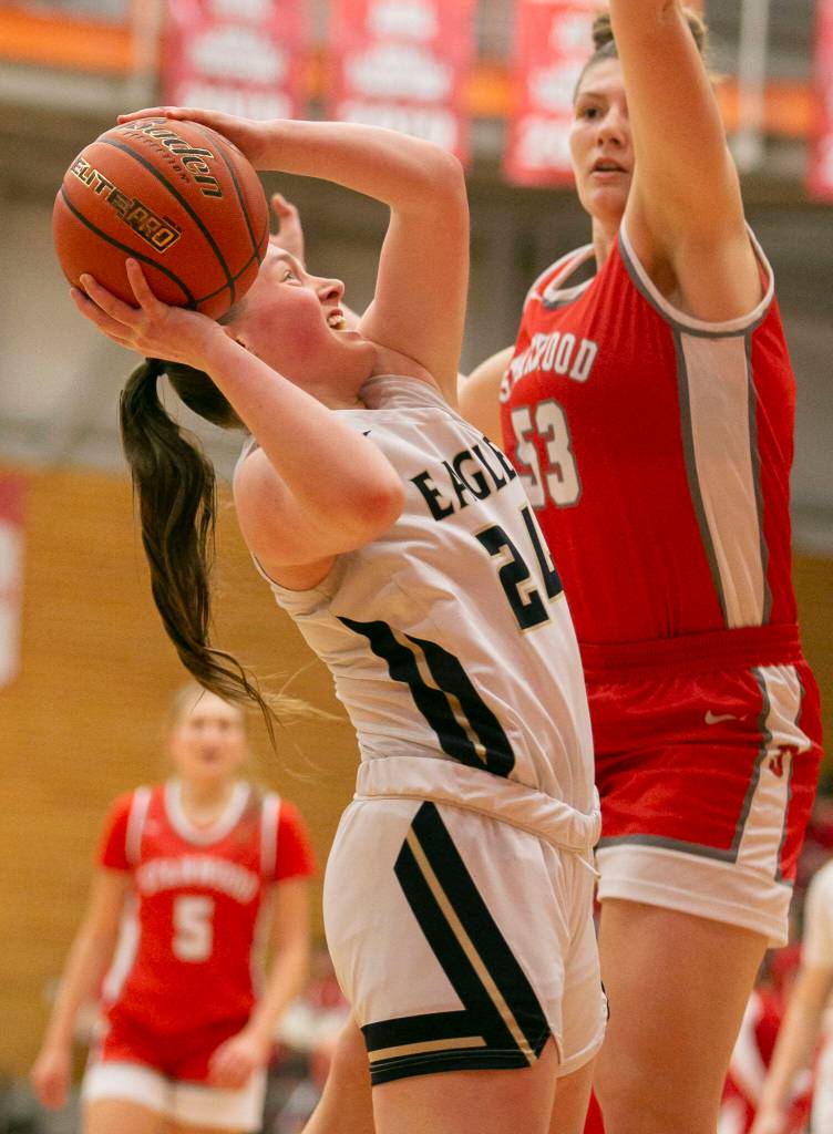 Arlingtons Katie Snow attempts a layup while guarded during the game against Stanwood on Saturday, Feb. 18, 2023 in Everett, Washington. (Olivia Vanni / The Herald)