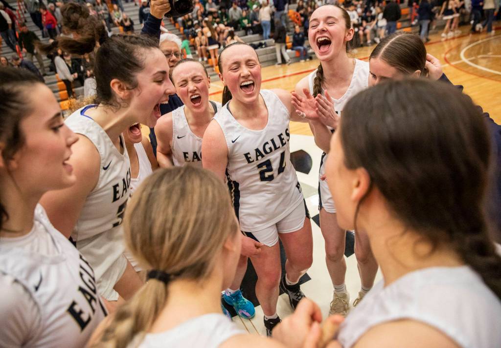 Arlignton players yell in celebration of becoming the 3A District 1 champions on Saturday, Feb. 18, 2023 in Everett, Washington. (Olivia Vanni / The Herald)