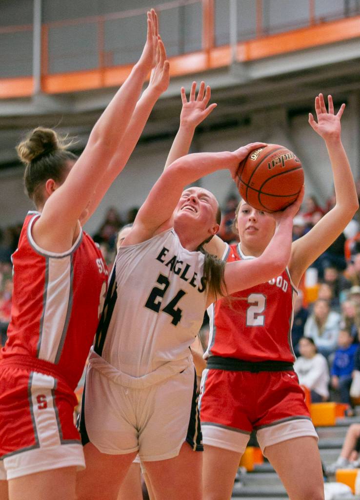 Arlingtons Katie Snow attempts a layup while double guarded during the game against Stanwood on Saturday, Feb. 18, 2023 in Everett, Washington. (Olivia Vanni / The Herald)