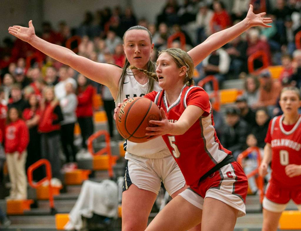 Stanwoods Ava Depew attempts to keep the ball away from Arlingtons Katie Snow during the game on Saturday, Feb. 18, 2023 in Everett, Washington. (Olivia Vanni / The Herald)