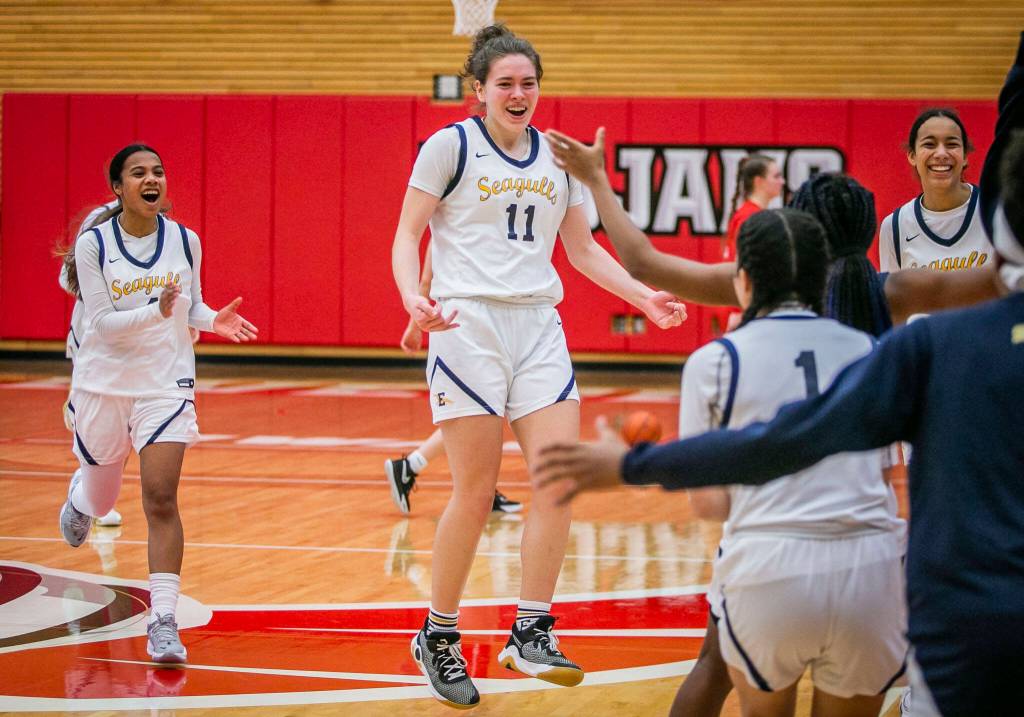 Everetts Lanie Thompson jumps in the air and runs to her teammates after beating Snohomish to advance to state on Saturday, Feb. 18, 2023 in Everett, Washington. (Olivia Vanni / The Herald)