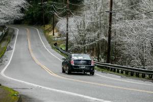 Snow falls off of a car driving through Forest Park on Wednesday, Feb. 22, 2023 in Everett, Washington. (Olivia Vanni / The Herald)
