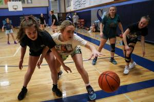 Wendy Asper (4), left, and Taylor Cushing (3), right, reach for the ball during a girls basketball practice at Sultan High School in Sultan, Washington on Thursday, Feb. 23, 2023. The Turks made the state playoffs for the first time in program history. (Annie Barker / The Herald)