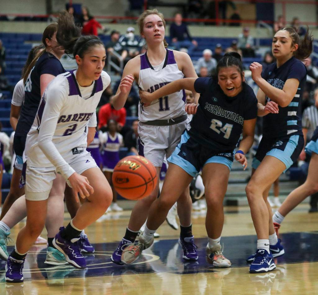 Players scramble for the ball during a 3A girls basketball state regional game between Garfield and Meadowdale at the Courter Family Athletic Pavilion in Bellevue on Friday. Garfield won 62-48. (Annie Barker / The Herald)