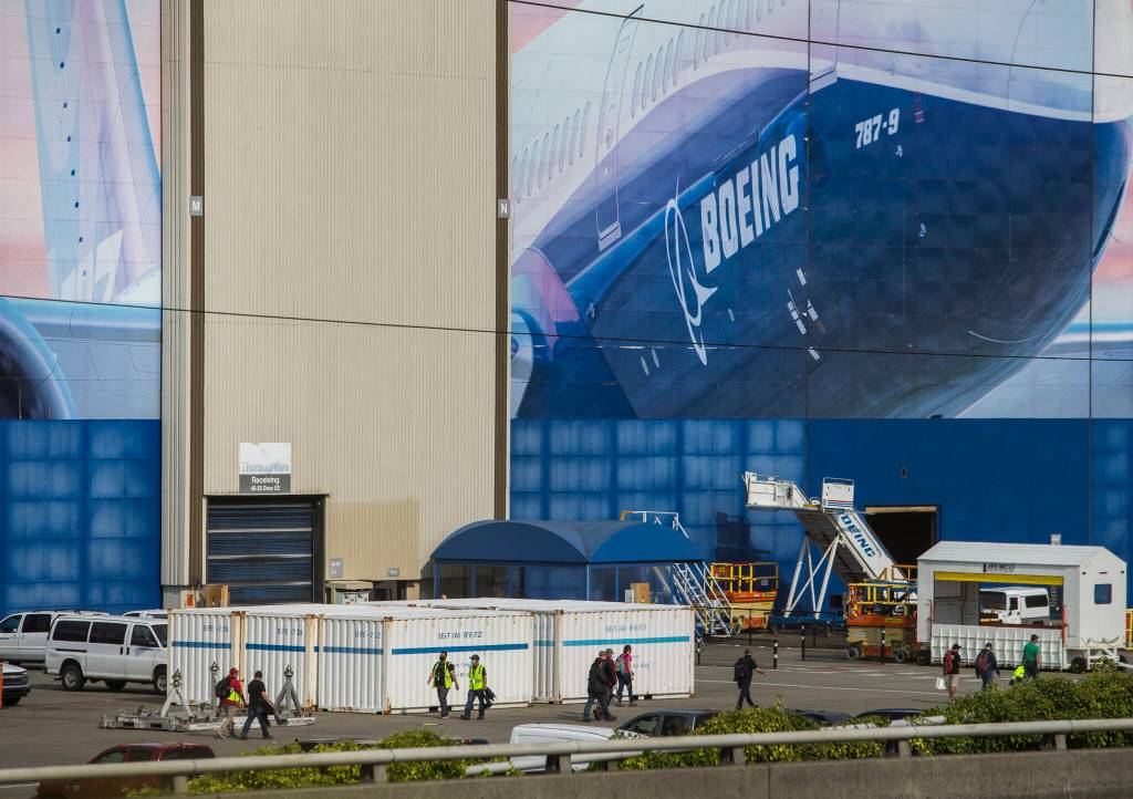 Boeing workers walk to and from their cars during a shift change on Oct. 1, 2020 in Everett. (Olivia Vanni / The Herald)