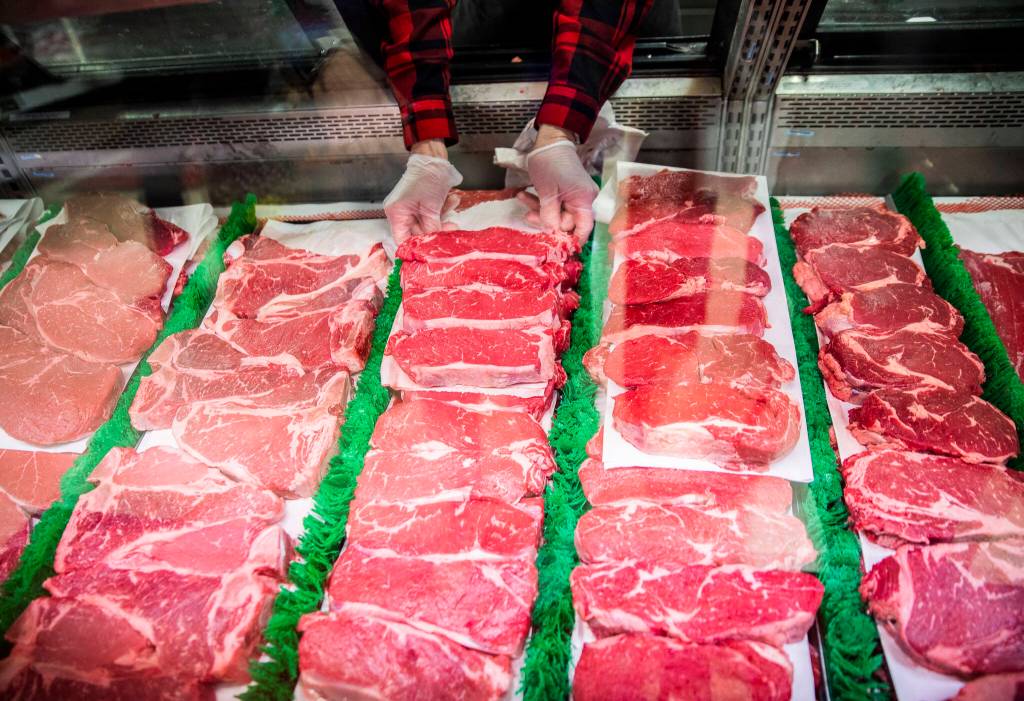 An employee puts out a selection of steaks at Double DD Meats. (Olivia Vanni / The Herald)