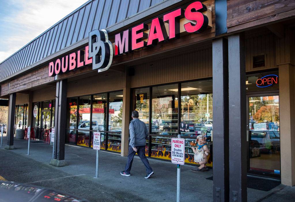 A customer walks out of Double DD Meats in Mountlake Terrace. (Olivia Vanni / The Herald)