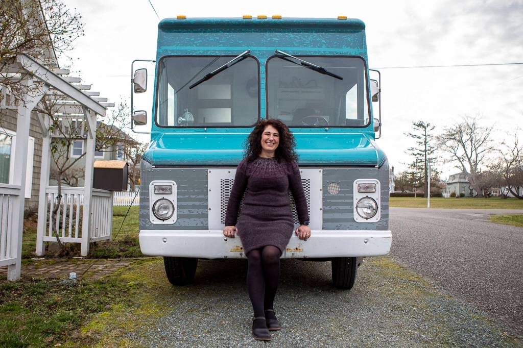 Willow Mietus, 50, on Feb. 1 stands in front of The Wool Wagon parked outside her home in Coupeville. (Annie Barker / The Herald)