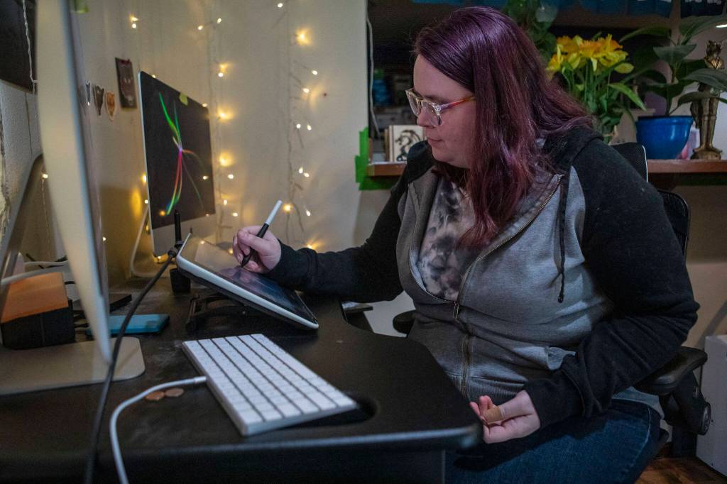 Nichole Matthews, 36, works on a digital drawing on Feb. 2 in her home in Lynnwood. (Annie Barker / The Herald)