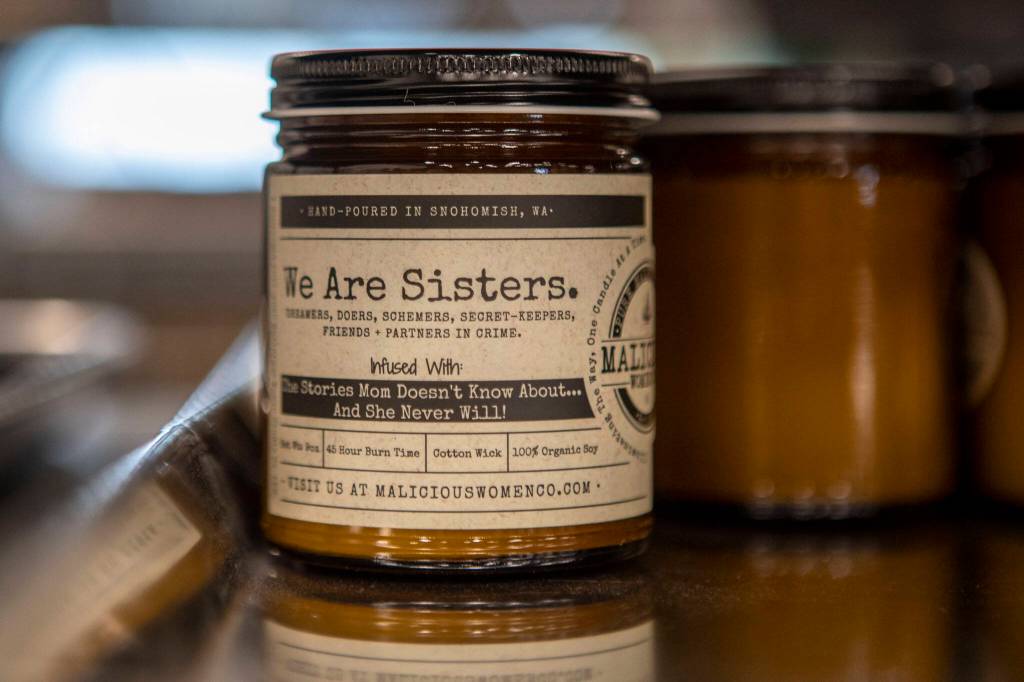 A We Are Sisters candle at the Malicious Women Candle Co workspace on Feb. 15 in Snohomish. The business is women run and owned. (Annie Barker / The Herald)