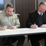 Snohomish County Sheriff Adam Fortney, left, and Snohomish County Executive Dave Somers sign a Partnership Agreement on Feb. 21. (Snohomish County)