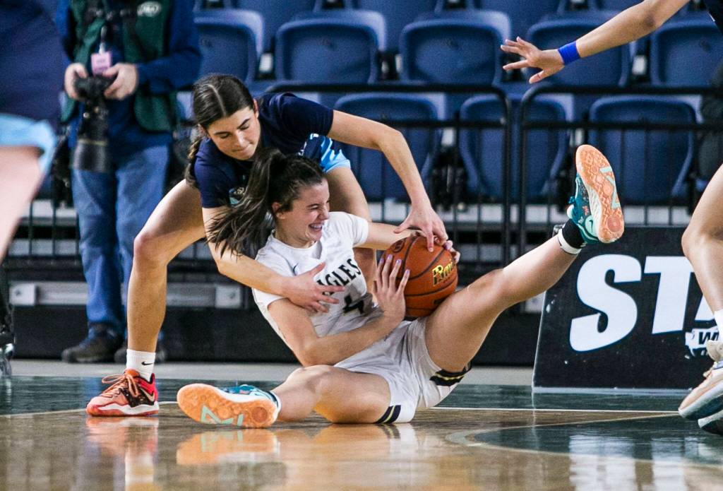 Arlingtons Maddy Fischer scrambles for the ball with Meadowdales Gia Powell during the 3A quarterfinal game against Meadowdale on Thursday, March 2, 2023 in Tacoma, Washington. (Olivia Vanni / The Herald)