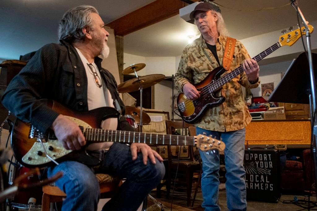 Lonnie Mueller, left, and Jim Kehoe chat during a Dan Canyon Band rehearsal in the groups practice barn in Arlington, Washington, on Saturday, March 11, 2023. (Annie Barker / The Herald)
