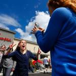 Chloe Charles (center) jumps into the middle of a picture being taken by Jada Summers of the girls respective mothers, Renee Charles (left) and Debbie Summers during the grand opening of Chick-Fil-As first Lynnwood location on May, 6 2015. (Mark Mulligan / The Herald)