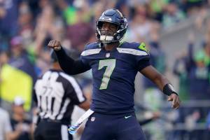 Seattle Seahawks quarterback Geno Smith (7) celebrates a touchdown run by running back Kenneth Walker III during the second half of an NFL football game against the Arizona Cardinals in Seattle, Sunday, Oct. 16, 2022. (AP Photo/Abbie Parr)