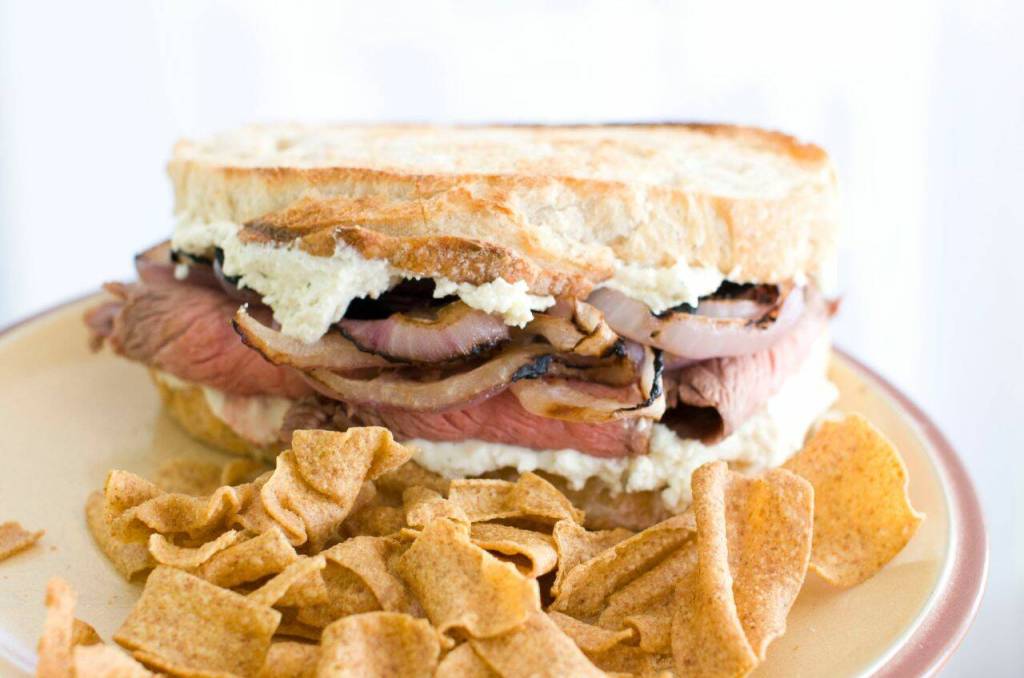 In this Feb. 6, 2012 image taken in Concord, N.H., a sandwich made of flank steak with slices of red onion marinated in Guinness lager and Boursin cheese, is shown. (AP Photo/Matthew Mead)