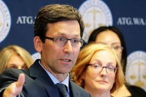 Washington Attorney General Bob Ferguson, center, talks to reporters, Monday, Aug. 26, 2019. (AP Photo/Ted S. Warren)