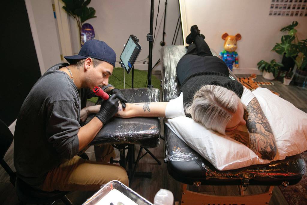 Hurtado works on a new tattoo for returning client Cheyenne Stultz. (Ryan Berry / The Herald)