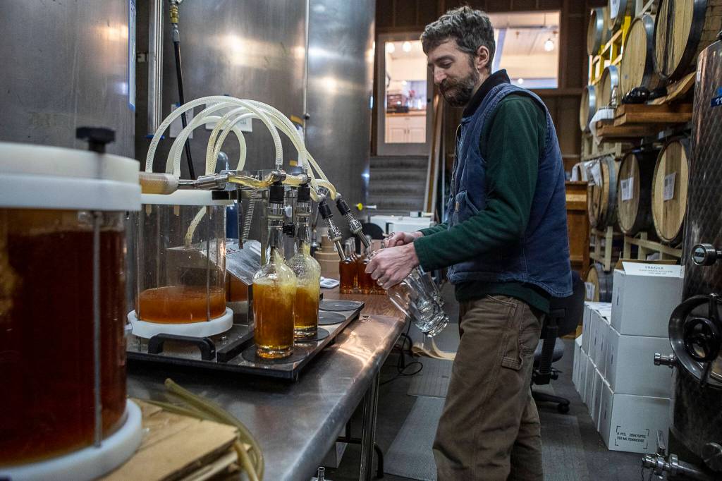 Production manager and distiller Brian Roys bottles rye whiskey at Skip Rock Distillers on March 3, 2023 in Snohomish, Washington. (Annie Barker / The Herald)