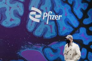 A man walks by Pfizer headquarters, Friday, Feb. 5, 2021, in New York. Pfizer will spend about $43 billion to buy Seagen and broaden its reach into cancer treatments, the pharmaceutical giant said Monday, March 13, 2023. (AP Photo / Mark Lennihan, File)