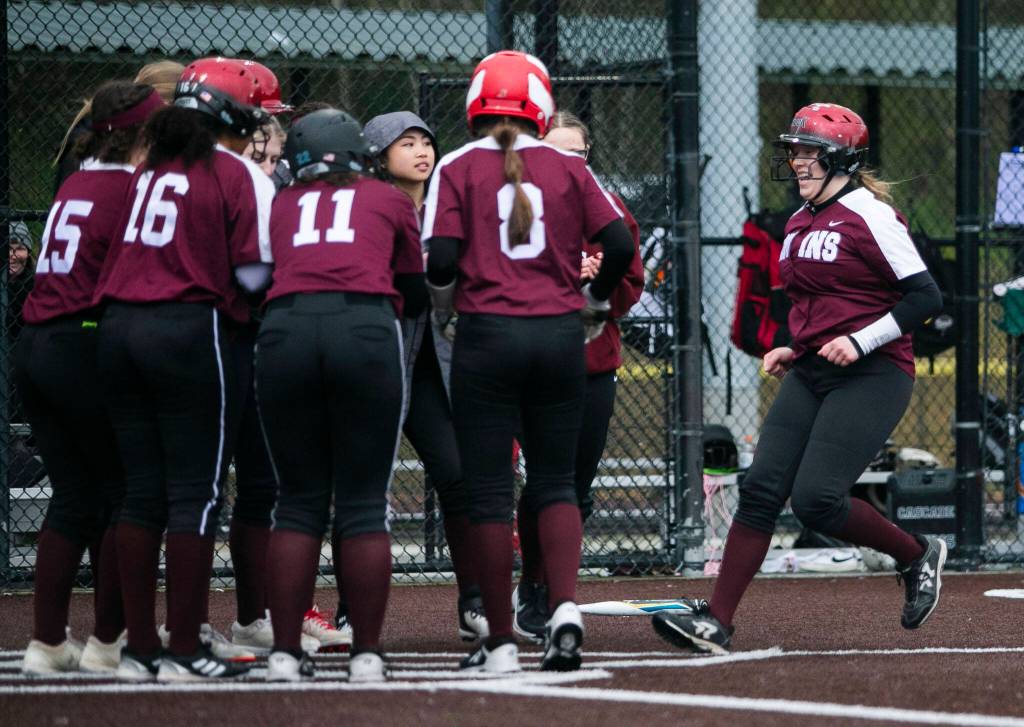 Cascades Alexa Hamshaw is congratulated by her teammates after hitting a home run during the game against Lakewood on Monday, March 13, 2023 in Everett, Washington. (Olivia Vanni / The Herald)