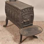 This cast-iron wood stove kept a 19th-century room warm. Its embossed designs, especially the rows of pointed arches on its sides, were meant to evoke medieval architecture.