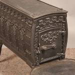 This cast-iron wood stove kept a 19th-century room warm. Its embossed designs, especially the rows of pointed arches on its sides, were meant to evoke medieval architecture.