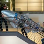 Artists Pieter and Lucy VanZanden haul a giant metal fish upstairs during the installation of Exploring The Edge at Schack Art Center on Sunday, March 19, 2023, in Everett, Washington. The fish, part of their three-piece ҃onsumption,Ӡis made from salvaged material and filled with single-use plastics that the couple have accumulated at home over the past five years. (Ryan Berry / The Herald)