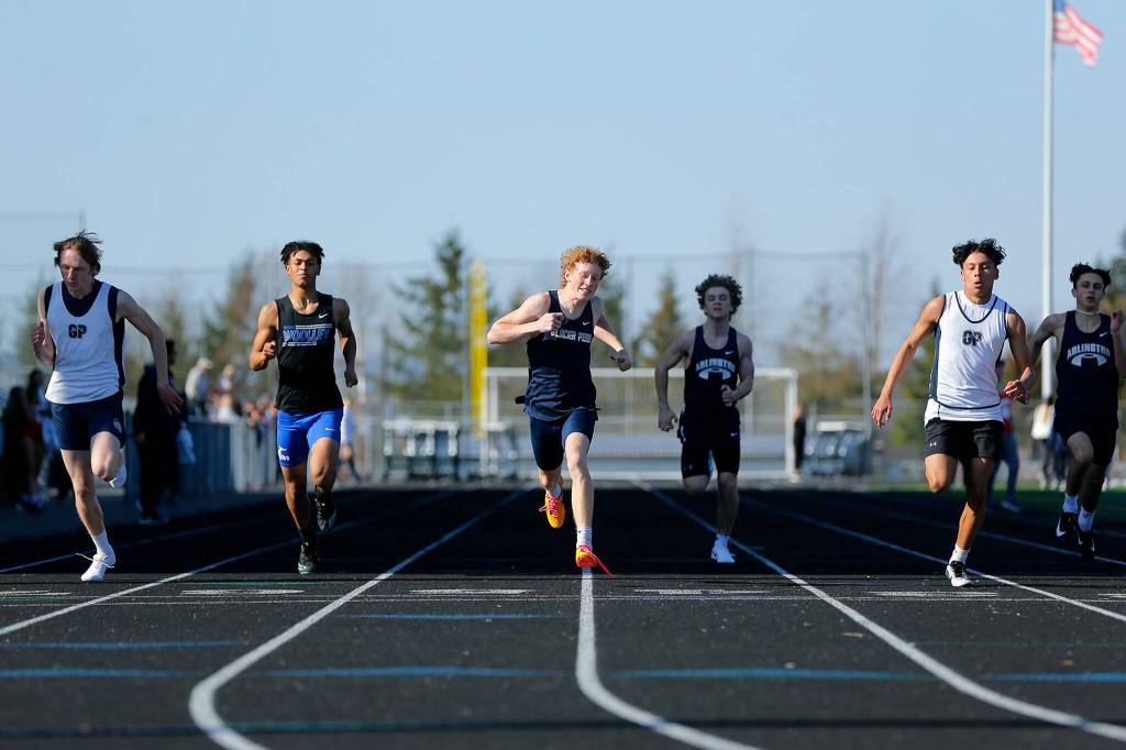 Runners cross the finish in the 200 meter dash during the Chuck Randall Invite at Arlington High School on Saturday, March 18, 2023, in Arlington, Washington. (Ryan Berry / The Herald)