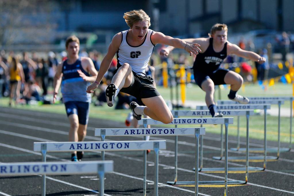 Runners compete in the 300 meter hurdle during the Chuck Randall Invite at Arlington High School on Saturday, March 18, 2023, in Arlington, Washington. (Ryan Berry / The Herald)