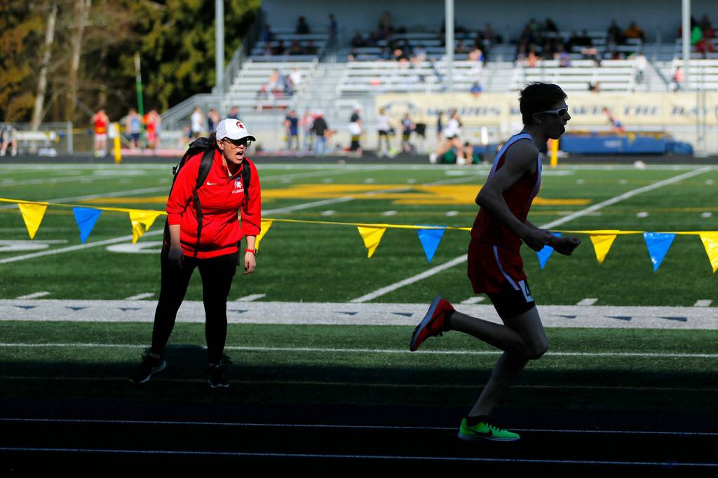 A Stanwood runner receives encouragement from the sideline while racing in the 800 meter run during the Chuck Randall Invite at Arlington High School on Saturday, March 18, 2023, in Arlington, Washington. (Ryan Berry / The Herald)