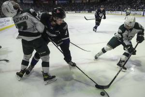 Silvertips’ Hunter Campbell (18) and Royals’ Justin Kipkie (3) fight for the puck during a game between the Everett Silvertips and Victoria Royals at the Angel of the Winds Arena on Friday, March 24, 2023. The Silvertips fell to the Royals, 6-4. (Annie Barker / The Herald)