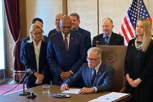 Gov. Jay Inslee signed legislation Thursday to add a ninth judge to the Snohomish County District Court. Sen. John Lovick, D-Mill Creek, who sponsored the bill, and Presiding District Court Judge Jennifer Rancourt look on. Taken March 30, 2023  (Jerry Cornfield / The Herald)