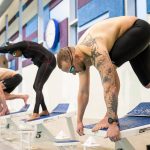 James Hessen sets himself on the the starting block before swimming during a practice with Everett YMCA’s US Masters swim team on Friday, March 17, 2023 in Everett, Washington. (Olivia Vanni / The Herald).