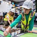 Matthew Sims places a traffic signal for his group's traffic project presentation at Hazelwood Elementary School on Wednesday, March 29, 2023, in Lynnwood, Washington. (Olivia Vanni / The Herald)