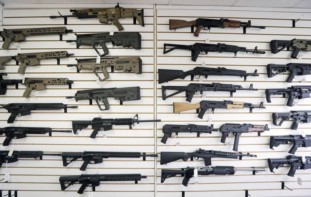 Semi-automatic rifles fill a wall at a gun shop in Lynnwood, Washington. (AP Photo/Elaine Thompson, File)