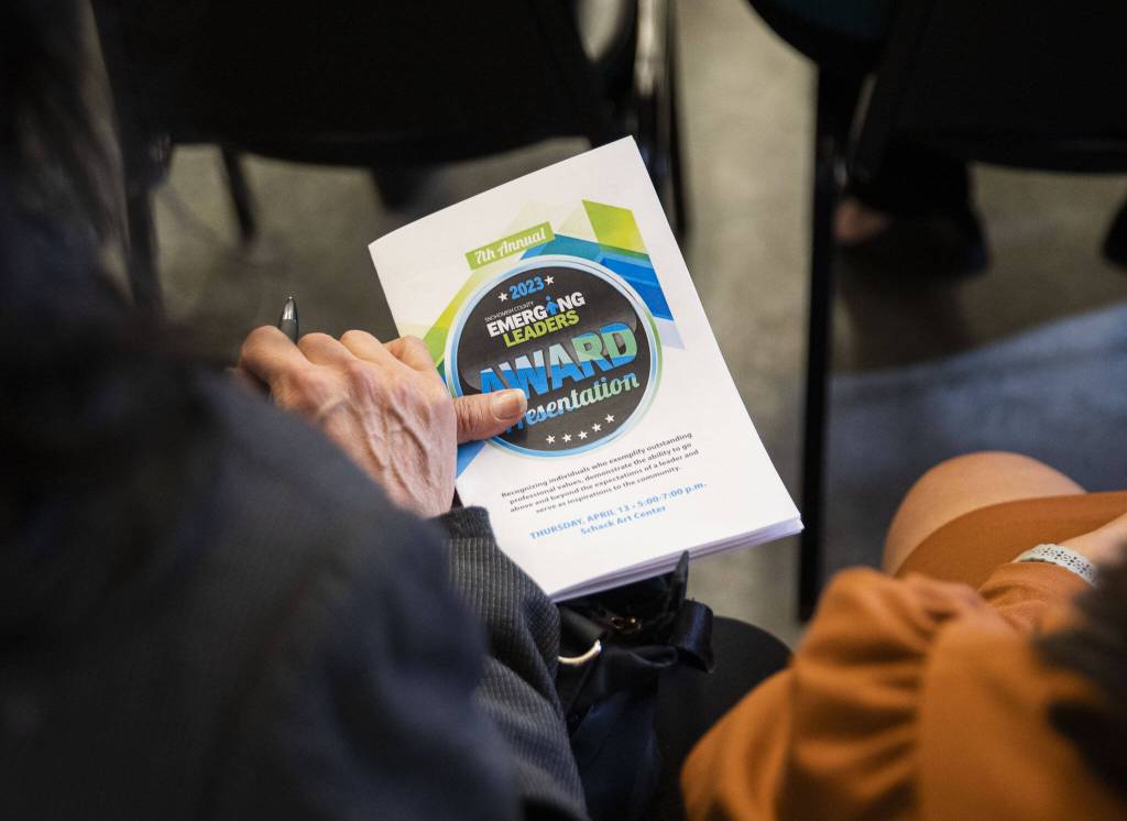 Audience members look through the emerging leader biographies on Thursday, April 13, 2023 in Everett, Washington. (Olivia Vanni / The Herald)