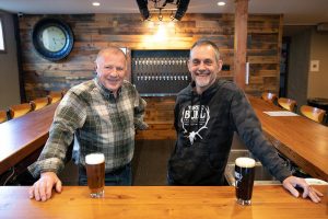 "Big Bull" Gary Pritzkau and his son Cary Pritzkau, who are two of multiple people involved in the operation of Three Bull Brewing, stand behind the bar at their new tap house on Wednesday, April 19, 2023, in downtown Snohomish, Washington. (Ryan Berry / The Herald)