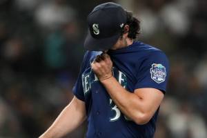 Seattle Mariners starting pitcher Robbie Ray wipes his face as he walks off of the field after being removed during the fourth inning of the team's baseball game against the Cleveland Guardians on Friday, March 31, 2023, in Seattle. (AP Photo/Lindsey Wasson)