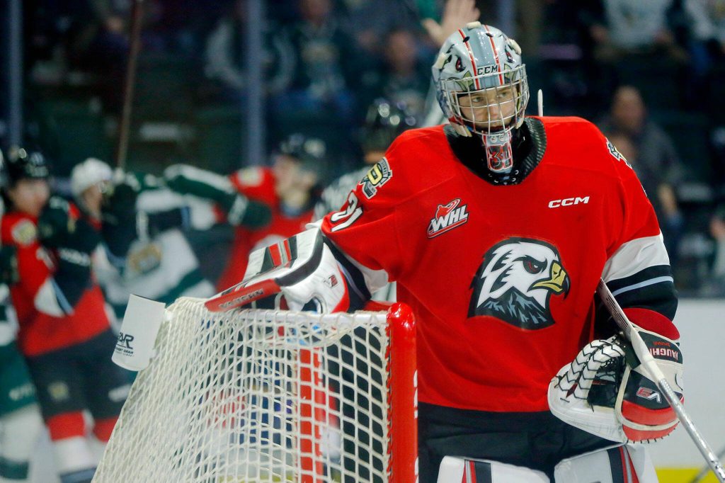 Winterhawks goalie Jan Spunar takes a breather as a fight breaks out behind him during game three of a playoff series against the Everett Silvertips on Monday, April 3, 2023, at Angel of the Winds Arena in Everett, Washington. (Ryan Berry / The Herald)