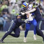Seattle Seahawks linebackers Uchenna Nwosu (left) and Bruce Irvin sack Los Angeles Rams quarterback Baker Mayfield during a game Jan. 8 in Seattle. (AP Photo/Ben VanHouten)